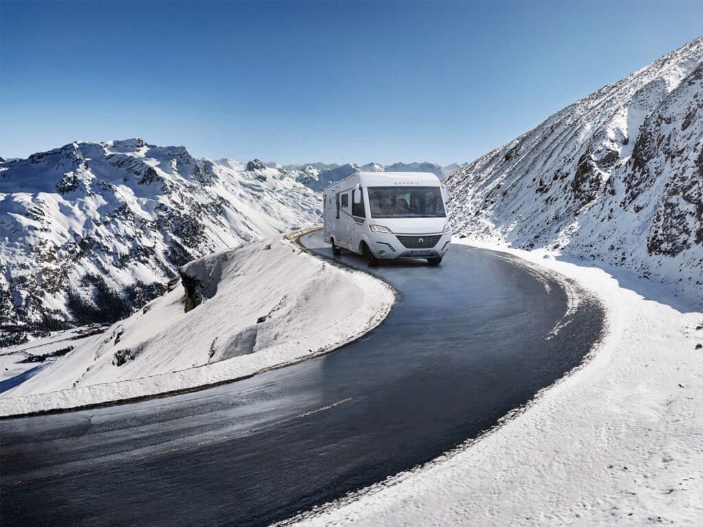 Camping-car intégral Bavaria roulant sur la route des stations de ski.