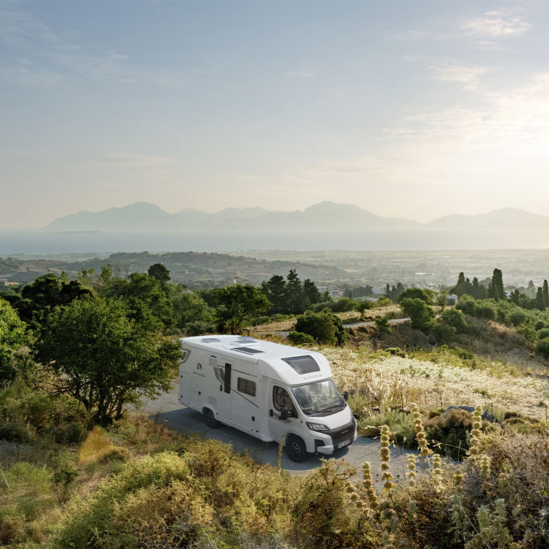 Camping-car profilé Bavaria à l'arrêt en milieu des champs.