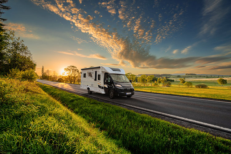 Camping-car profilé Bavaria roulant sur une route en campagne