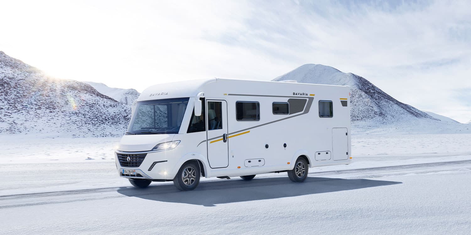 Camping-car intégral Bavaria roulant sur une route enneigée