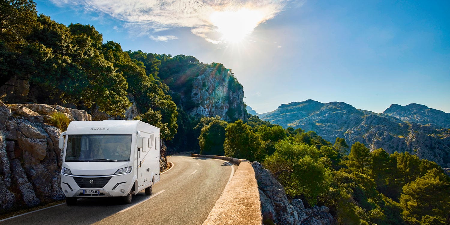 Camping-car intégral Bavaria roulant sur une route de montagne