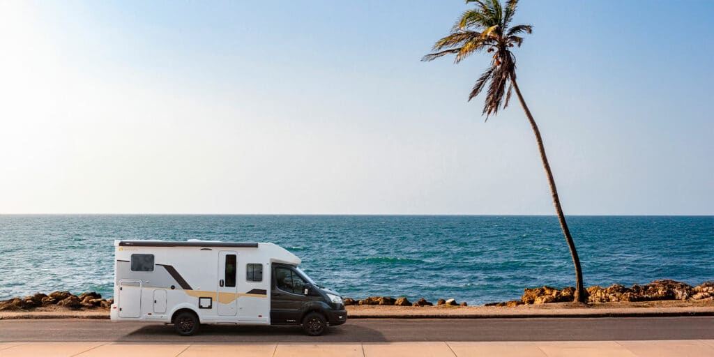 Camping-car Profilé compact roulant sur une route en bord de mer