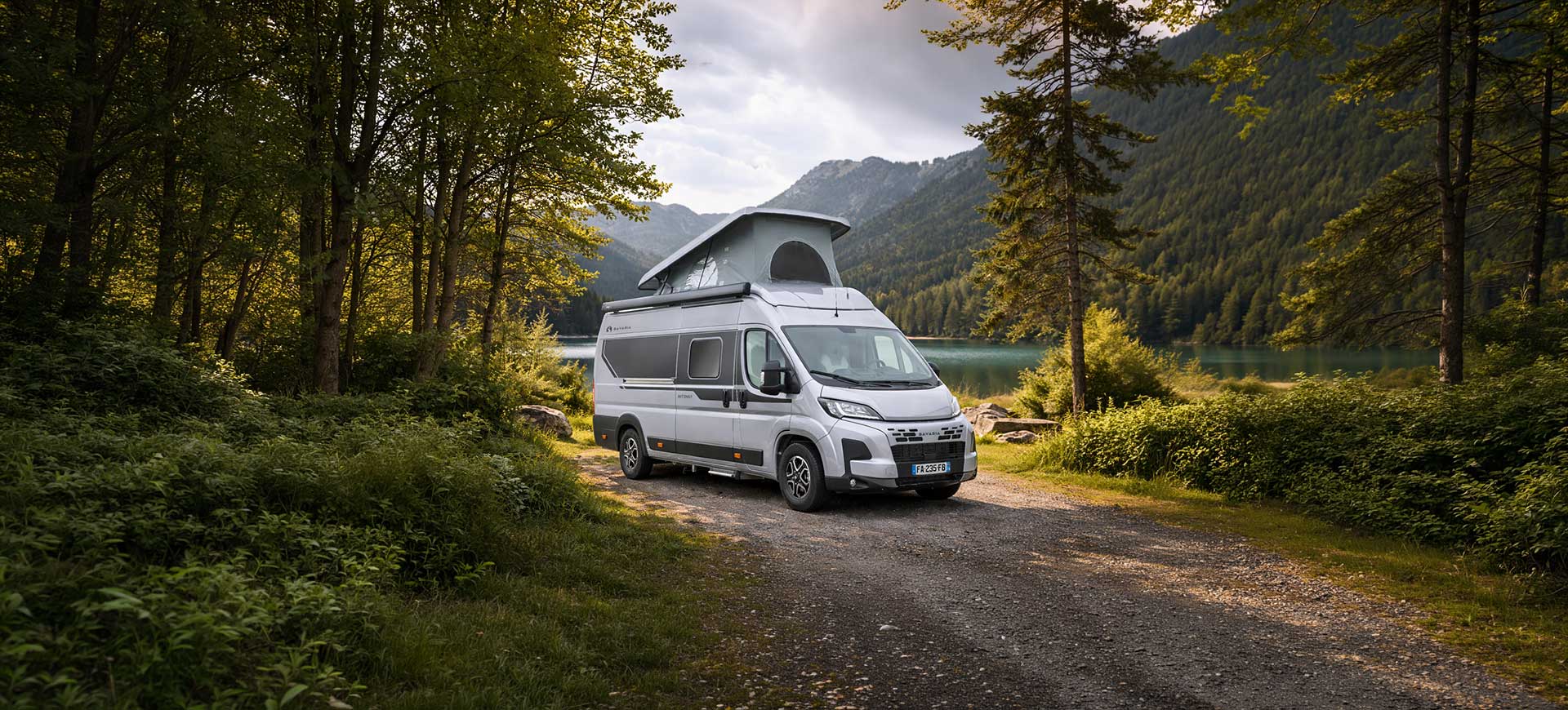 Nouveau fourgon aménagé Bavaria avec un toit relevable en pleine forêt.