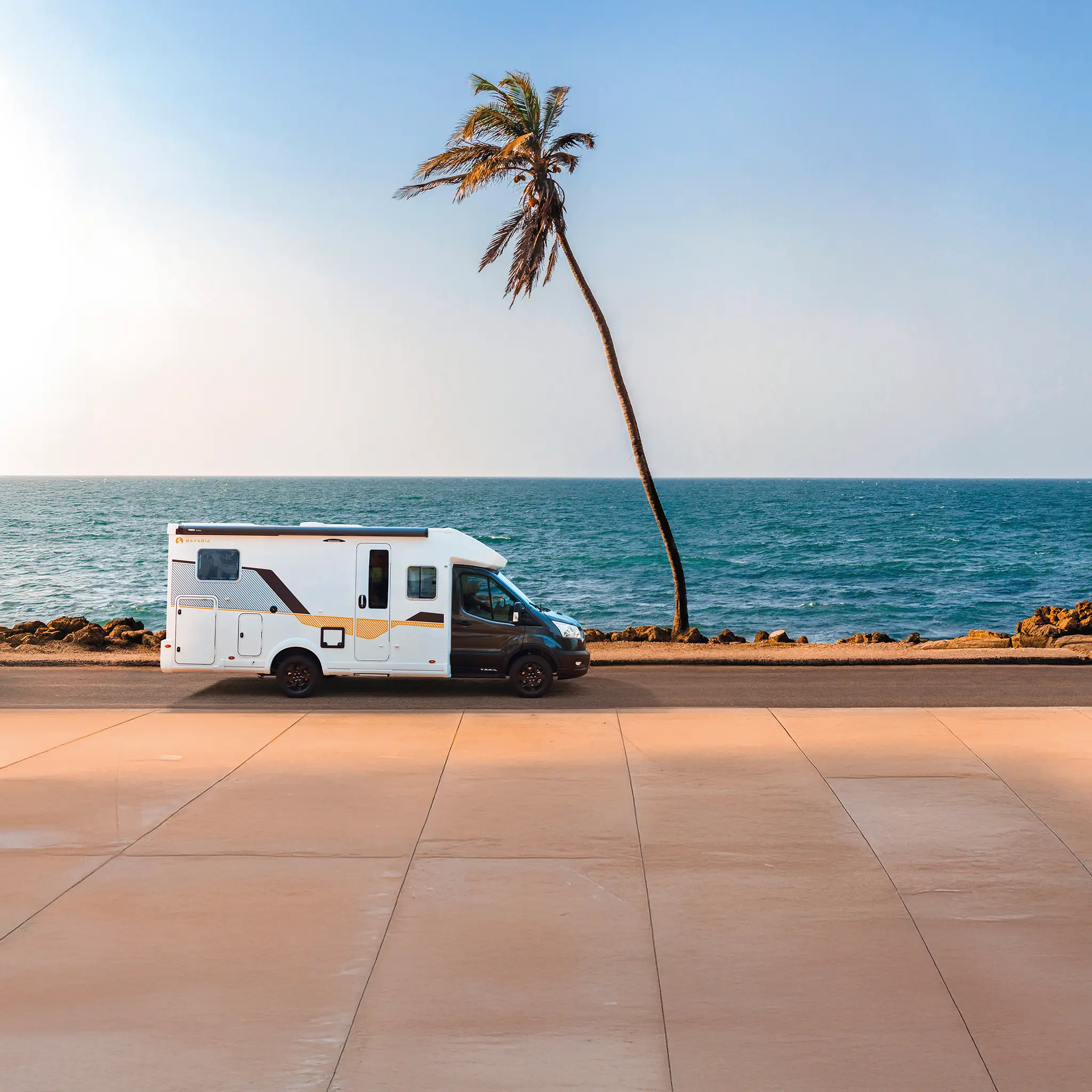 Camping car profilé étroit sur une route en bord de mer