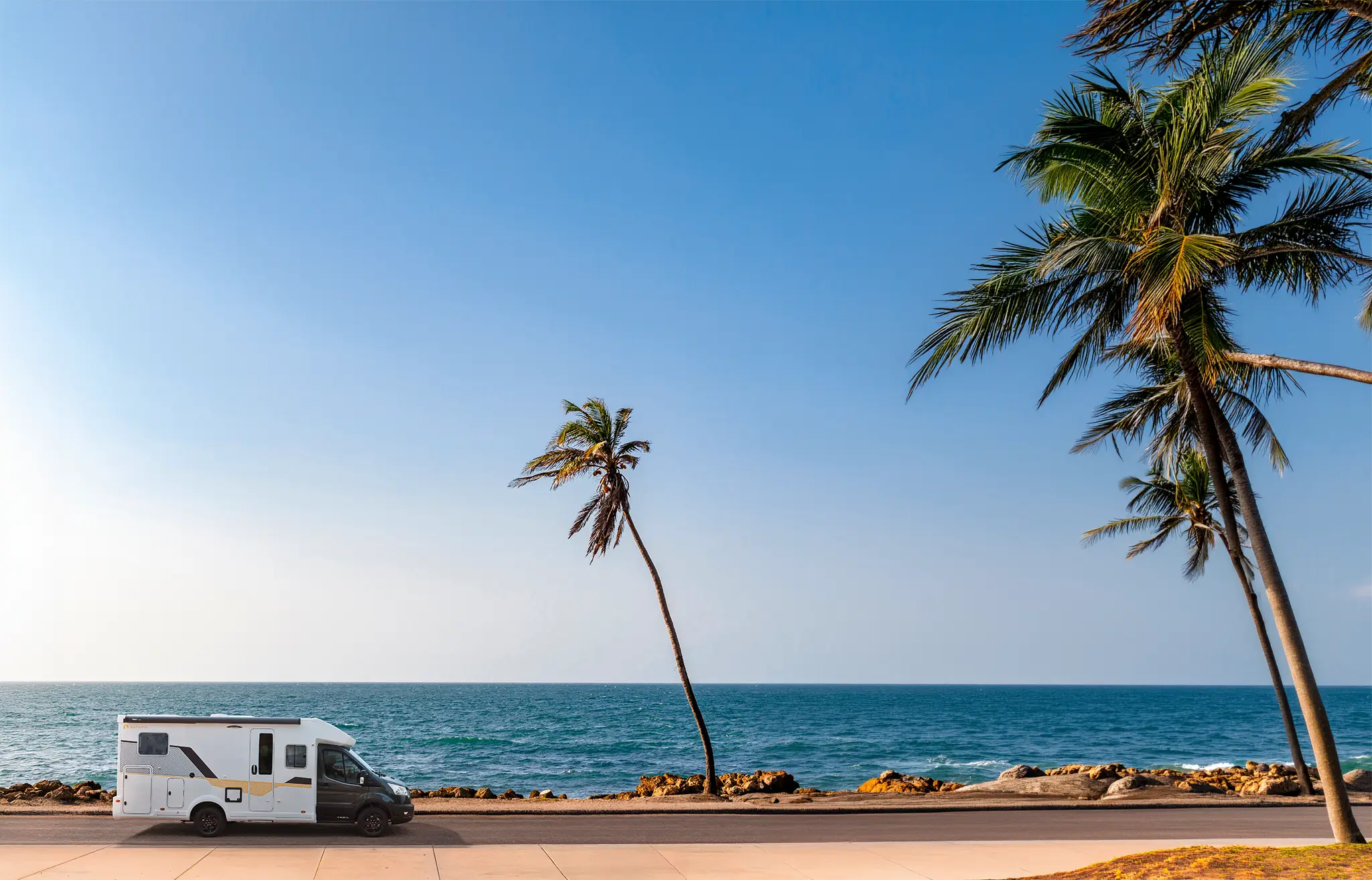 Camping car profilé étroit sur une route en bord de mer